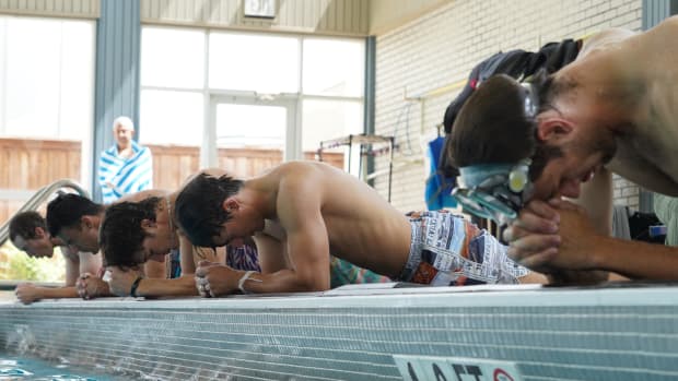 Men planking outside of a pool to build strength in their core