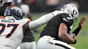 Dec 7, 2025; Paradise, Nevada, USA;  Las Vegas Raiders quarterback Geno Smith (7) is sacked by Denver Broncos defensive tackle Malcolm Roach (97) during the first half at Allegiant Stadium. Mandatory Credit: Kirby Lee-Imagn Images
