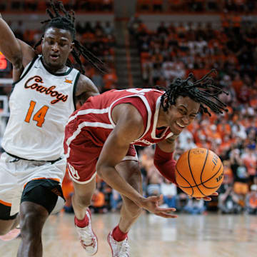 Feb 24, 2024; Stillwater, Oklahoma, USA; Oklahoma Sooners guard Javian McCollum (2) gets tripped up by Oklahoma State Cowboys guard Jamyron Keller (14) during the second half at Gallagher-Iba Arena. Mandatory Credit: William Purnell-Imagn Images