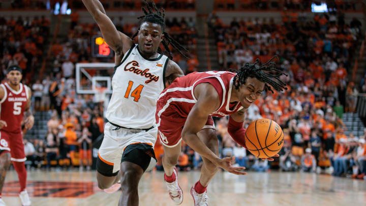 Feb 24, 2024; Stillwater, Oklahoma, USA; Oklahoma Sooners guard Javian McCollum (2) gets tripped up by Oklahoma State Cowboys guard Jamyron Keller (14) during the second half at Gallagher-Iba Arena. Mandatory Credit: William Purnell-USA TODAY Sports