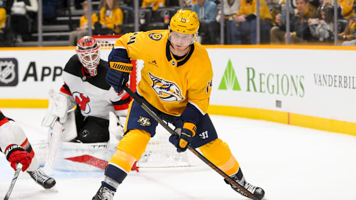 Feb 23, 2025; Nashville, Tennessee, USA;  Nashville Predators center Gustav Nyquist (14) skates with the puck against the New Jersey Devils during the third half at Bridgestone Arena. Mandatory Credit: Steve Roberts-Imagn Images