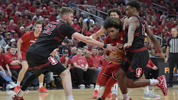 Mar 8, 2025; Louisville, Kentucky, USA;  Louisville Cardinals guard Chucky Hepburn (24) drives to the basket against Stanford Cardinal forward Aidan Cammann (52) and guard Jaylen Blakes (21) during the second half at KFC Yum! Center. Louisville defeated Stanford 68-48. Mandatory Credit: Jamie Rhodes-Imagn Images