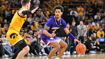 Feb 22, 2025; Iowa City, Iowa, USA; Washington Huskies guard DJ Davis (4) controls the ball as Iowa Hawkeyes guard Brock Harding (2) defends during the first half at Carver-Hawkeye Arena. Mandatory Credit: Jeffrey Becker-Imagn Images
