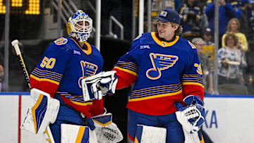 Mar 13, 2024; St. Louis, Missouri, USA;  St. Louis Blues goaltender Jordan Binnington (50) celebrates with goaltender Joel Hofer (30) after the Blues defeated the Los Angeles Kings at Enterprise Center. Mandatory Credit: Jeff Curry-Imagn Images