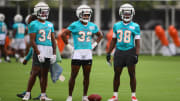 Jul 24, 2024; Miami Gardens, FL, USA; Miami Dolphins safety Jordan Colbert (34), safety Patrick McMorris (32), and safety Mark Perry (38) look on during training camp at Baptist Health Training Complex.