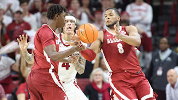 Feb 8, 2025; Fayetteville, Arkansas, USA; Arkansas Razorbacks forward Trevon Brazile (4) attempts to break up a pass to Alabama Crimson Tide guard Chris Youngblood (8) during the first half at Bud Walton Arena. Mandatory Credit: Nelson Chenault-Imagn Images