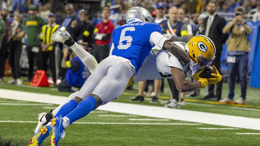 Nov 27, 2025; Detroit, Michigan, USA; Green Bay Packers wide receiver Dontayvion Wicks (13) dives for the endzone for a touchdown against Detroit Lions cornerback Terrion Arnold (6) during the third quarter at Ford Field. Mandatory Credit: David Reginek-Imagn Images