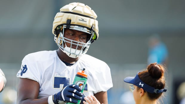 Freshman offensive tackle Guerby Lambert takes a break for water during a hot morning as Notre Dame opened fall camp 