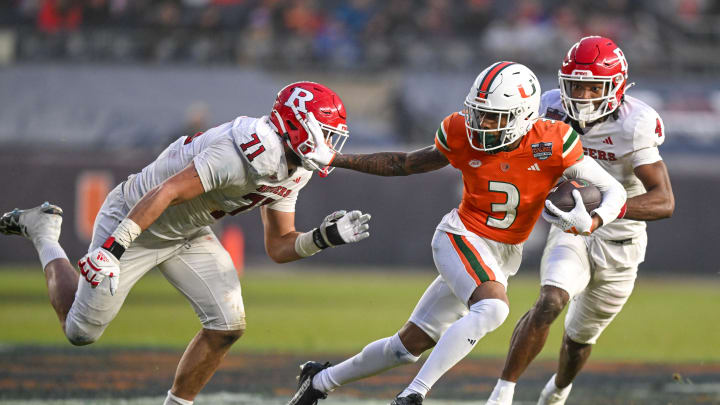 Dec 28, 2023; Bronx, NY, USA; Miami Hurricanes wide receiver Jacolby George (3) runs with the ball chased by Rutgers Scarlet Knights defensive lineman Aaron Lewis (71) during the third quarter at Yankee Stadium. Mandatory Credit: Mark Smith-USA TODAY Sports