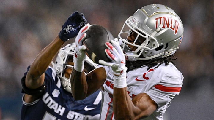 UNLV Rebels wide receiver Ricky White III (11) catches a touchdown pass in front of Utah State Aggies cornerback Avante Dickerson (17) in the first half at Merlin Olsen Field at Maverik Stadium. UNLV Rebels wide receiver Ricky White III (11) catches a touchdown pass in front of Utah State Aggies cornerback Avante Dickerson (17) in the first half at Merlin Olsen Field at Maverik Stadium.