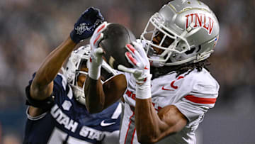 UNLV Rebels wide receiver Ricky White III (11) catches a touchdown pass in front of Utah State Aggies cornerback Avante Dickerson (17) in the first half at Merlin Olsen Field at Maverik Stadium. Mandatory Credit: Jamie Sabau-Imagn Images