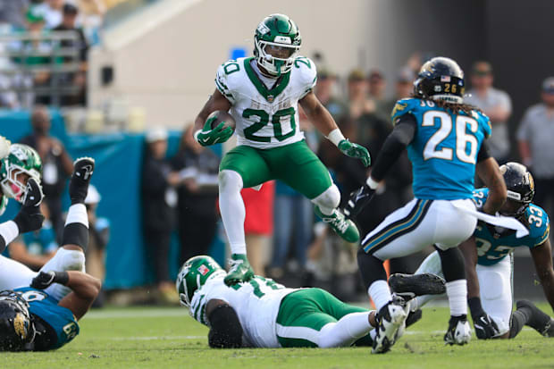 New York Jets running back Breece Hall (20) leaps while rushing for yards during the third quarter