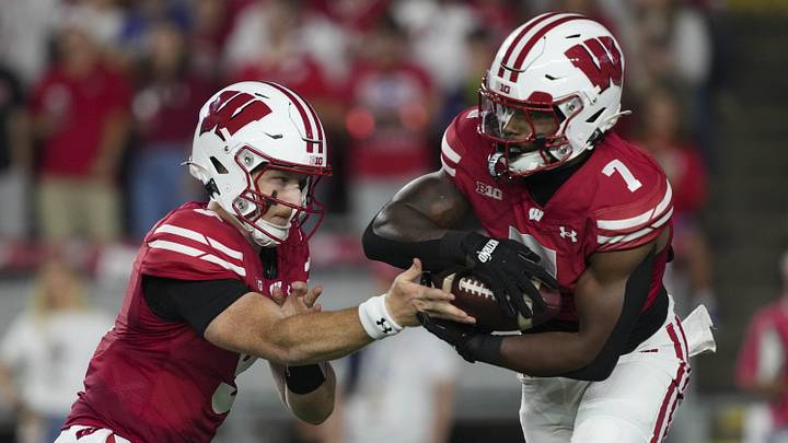 Aug 28, 2025; Madison, Wisconsin, USA;  Wisconsin Badgers quarterback Billy Edwards Jr. (9) hands the football off to running back Dilin Jones (7) during the first quarter against the Miami (OH) RedHawks at Camp Randall Stadium. Mandatory Credit: Jeff Hanisch-Imagn Images