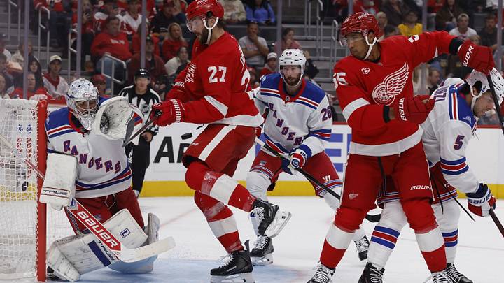 Oct 2, 2026; Detroit, Michigan, USA;  Detroit Red Wings center Michael Rasmussen (27) tries to deflect the puck in front of New York Rangers goalie Dylan Garand in the second period at Little Caesars Arena.  Mandatory Credit: Rick Osentoski-Imagn Images