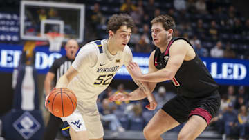 Nov 17, 2025; Morgantown, West Virginia, USA; West Virginia Mountaineers guard Treysen Eaglestaff (52) drives against Lafayette Leopards forward Andrew Phillips (21) during the second half at WVU Coliseum. Mandatory Credit: Ben Queen-Imagn Images