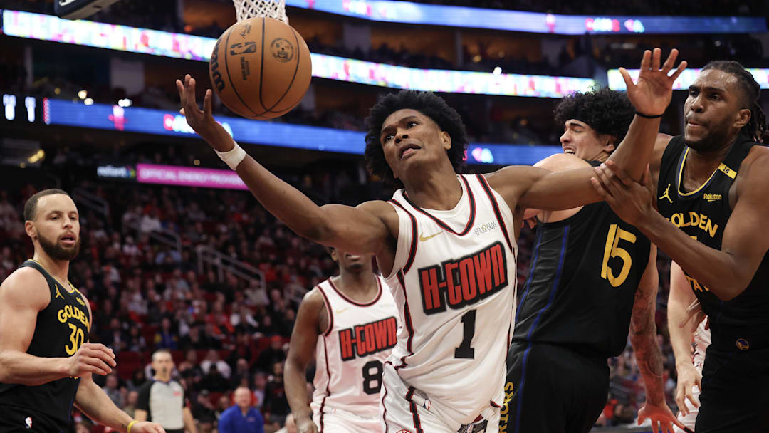 Feb 13, 2025; Houston, Texas, USA; Houston Rockets forward Amen Thompson (1) and Golden State Warriors forward Kevon Looney (5) reach for a rebound in the second  half at Toyota Center. Mandatory Credit: Thomas Shea-Imagn Images