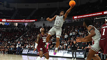 Feb 18, 2025; Starkville, Mississippi, USA; Mississippi State Bulldogs guard Josh Hubbard (12) shoots against Texas A&M Aggies guard Manny Obaseki (35) during the second half at Humphrey Coliseum. Mandatory Credit: Petre Thomas-Imagn Images