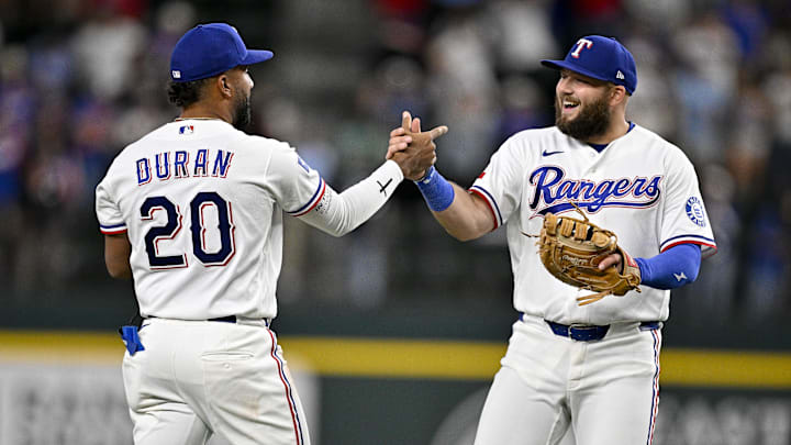 Apr 6, 2026; Arlington, Texas, USA; Texas Rangers first baseman Jake Burger (21) and third baseman Ezequiel Duran (20) celebrate the Rangers win over the Seattle Mariners at Globe Life Field. Mandatory Credit: Jerome Miron-Imagn Images