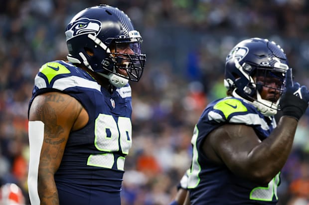 Seattle Seahawks defensive end Leonard Williams (99) celebrates a sack by defensive tackle Jarran Reed (90, right).