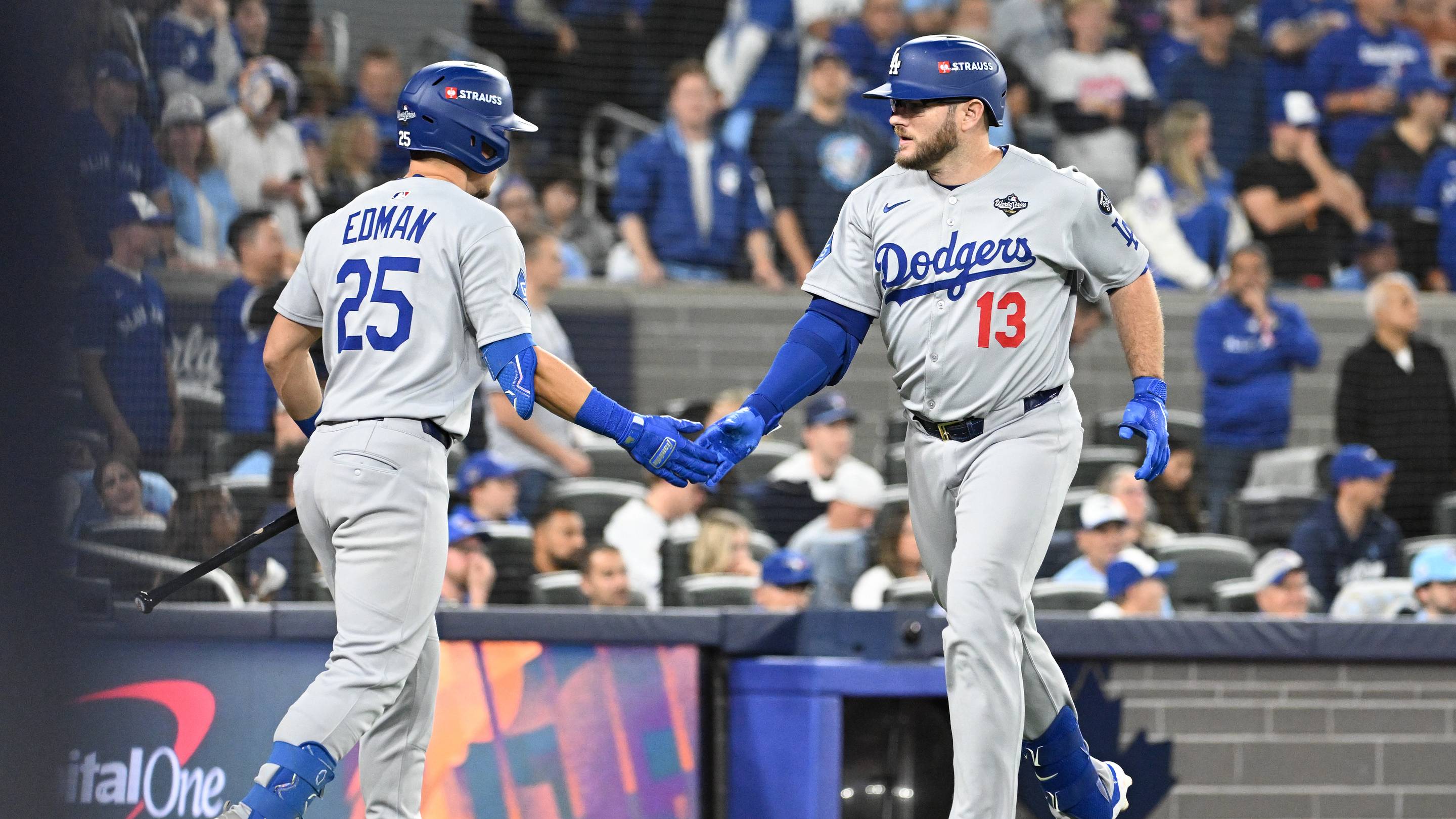 Oct 25, 2025; Toronto, Ontario, CAN; Los Angeles Dodgers third baseman Max Muncy (13) celebrates after hitting a solo home run against the Toronto Blue Jays with second baseman Tommy Edman (25) in the seventh inning during game two of the 2025 MLB World Series at Rogers Centre. Mandatory Credit: Dan Hamilton-Imagn Images
