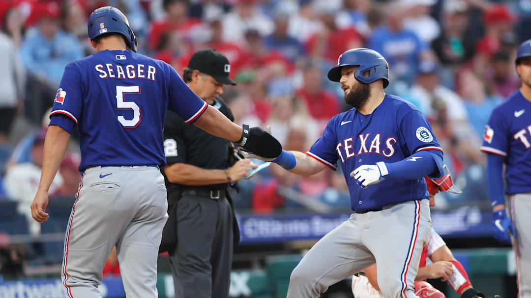Mar 26, 2026; Philadelphia, Pennsylvania, USA; Texas Rangers first baseman Jake Burger (21) shakes hands with shortstop Corey Seager (5) after hitting a two RBI homer run against the Philadelphia Phillies during the ninth inning at Citizens Bank Park. Mandatory Credit: Bill Streicher-Imagn Images