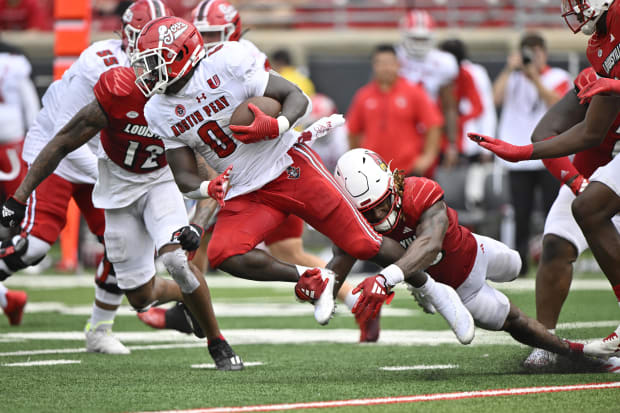 Austin Peay Governors running back O'Shaan Allison (0) runs the ball against Louisville defensive back Benjamin Perry (10)