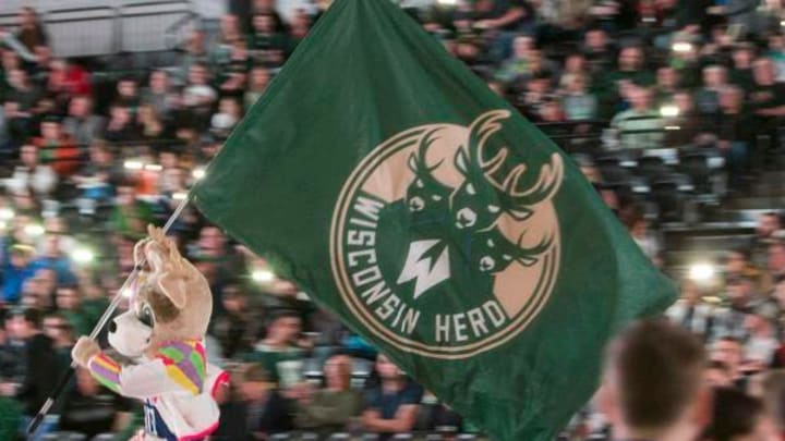 The Wisconsin Herd mascot runs the flag onto the court at Menominee Nation Arena in Oshkosh.