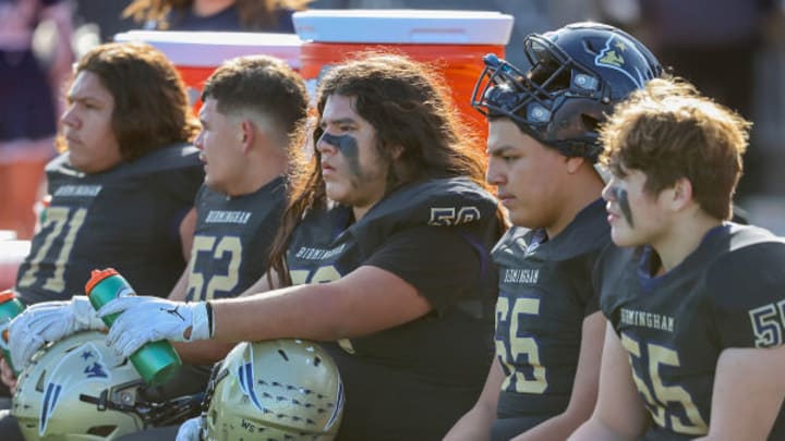 Birmingham Charter football linemen sit on the bench during their CIF State final in December of 2023 against Acalanes.