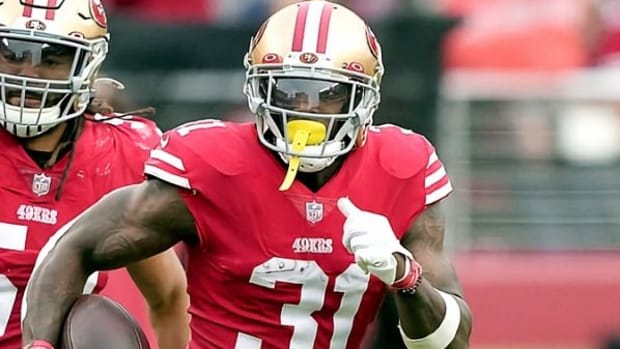 49ers safety Tashaun Gipson Sr. (red jersey with white numbers and gold helmet) runs with the ball. 