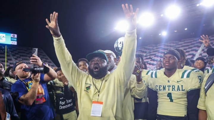 Miami Central head coach Jube Joseph raises his arms in celebration after his Rockets captured the 2022 FHSAA Class 2M state championship, the program's fourth consecutive state title at that time.
