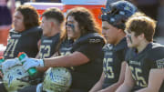 Birmingham Charter football linemen sit on the bench during their CIF State final in December of 2023 against Acalanes.