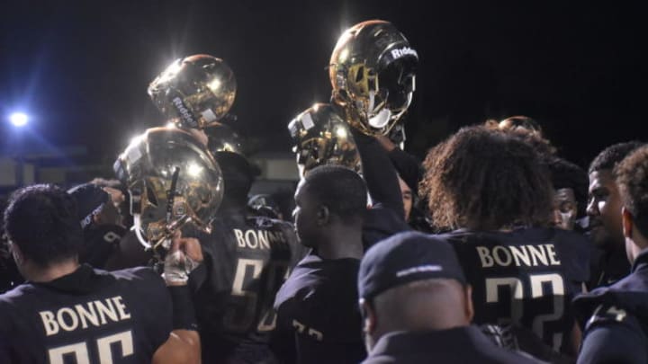 Narbonne football players in a huddle before a game.