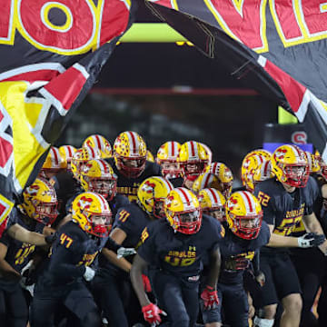 Mission Viejo football team bursts through a banner before kickoff.
