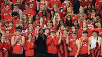 The Eden Prairie student section celebrates during a football game. 