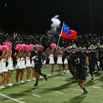 St. John Bosco football team runs out on the field against Mater Dei in 2023.