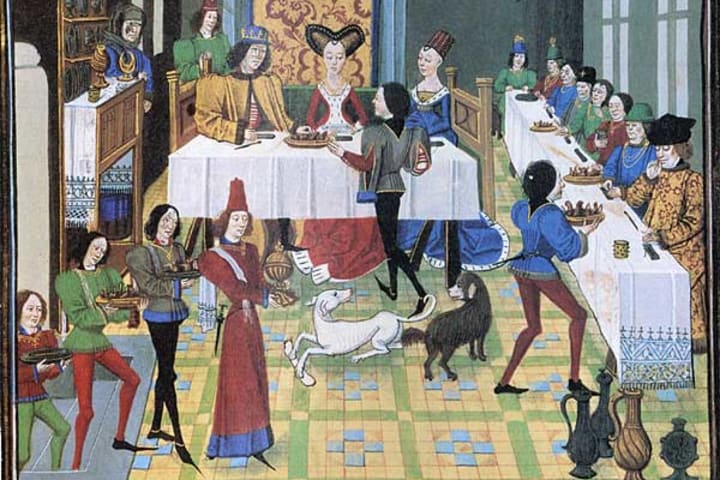 A 15th century image of a French banquet with dogs present