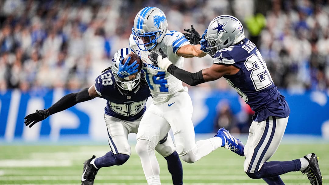 Detroit Lions wide receiver Amon-Ra St. Brown makes a catch against Dallas Cowboys safety Malik Hooker (28) and cornerback DaRon Bland (26) during the first half at Ford Field in Detroit on Thursday, Dec. 4, 2025.