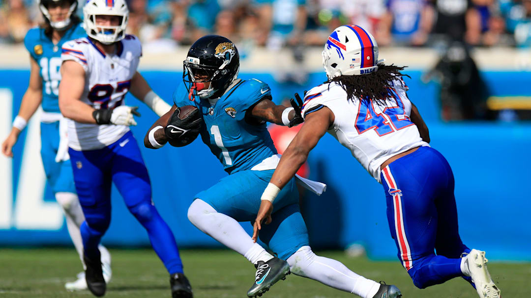 Jacksonville Jaguars running back Travis Etienne Jr. (1) rushes for yards against Buffalo Bills linebacker Dorian Williams (42) during the first quarter of an NFL football AFC Wild Card playoff matchup, Sunday, Jan. 11, 2026, in Jacksonville, Fla. The Bills defeated the Jaguars 27-24. [Corey Perrine/Florida Times-Union]