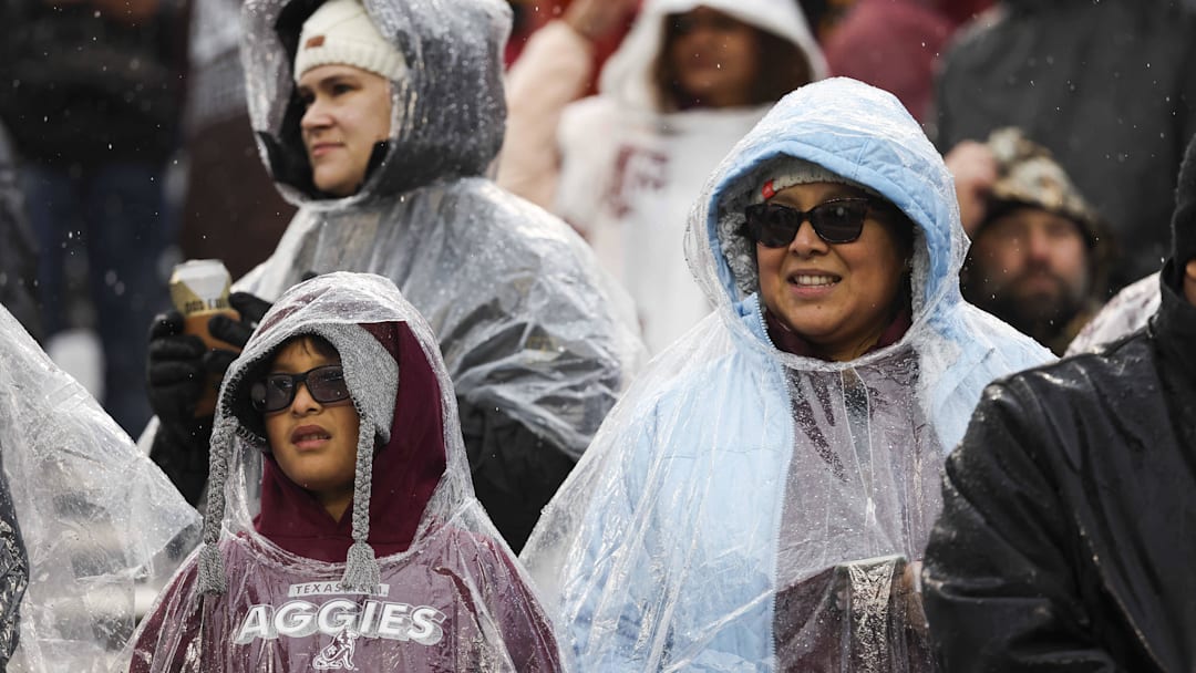 Nov 19, 2022; College Station, Texas, USA; Fans wear rain protection while watching the game between the Texas A&M Aggies and the Massachusetts Minutemen at Kyle Field. Mandatory Credit: Troy Taormina-Imagn Images