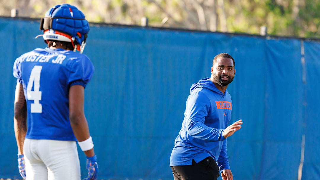 Florida Gators assistant coach for defensive backs Deron Wilson instructs Florida Gators defensive back Teddy Foster (4) during spring football practice at Heavener Football Complex at the University of Florida in Gainesville, FL on Thursday, March 6, 2025. [Matt Pendleton/Gainesville Sun]