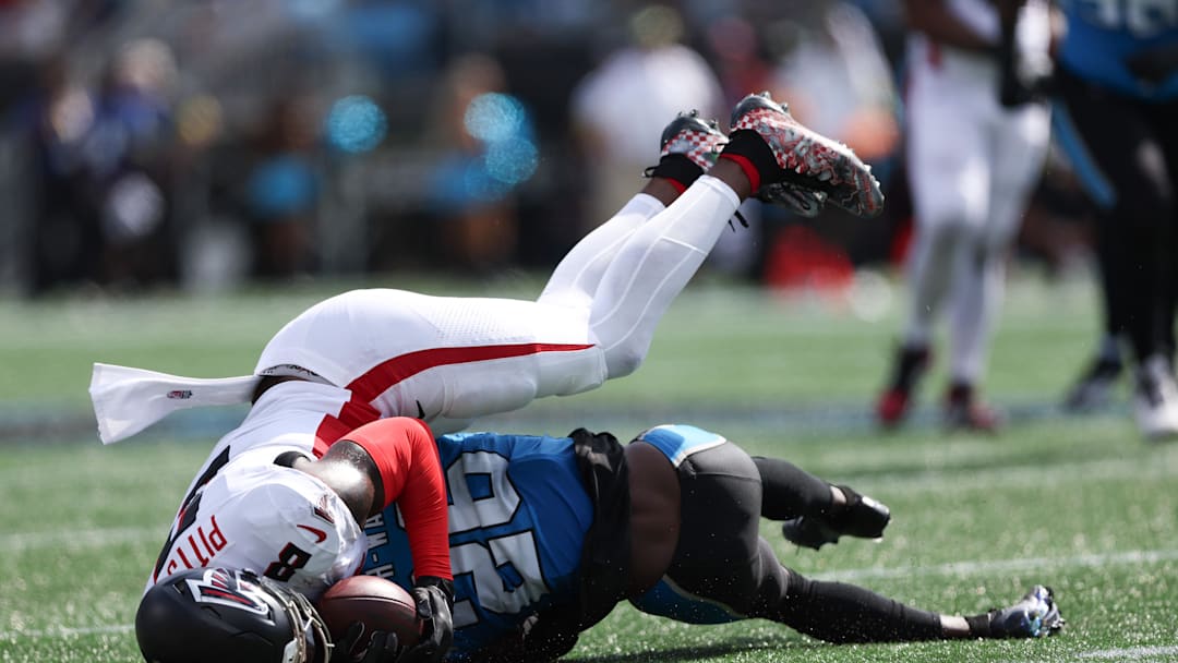 Sep 21, 2025; Charlotte, North Carolina, USA; Atlanta Falcons tight end Kyle Pitts (8) gets tackled by Carolina Panthers cornerback Chau Smith-Wade (26) during the second half of a game at Bank of America Stadium. 