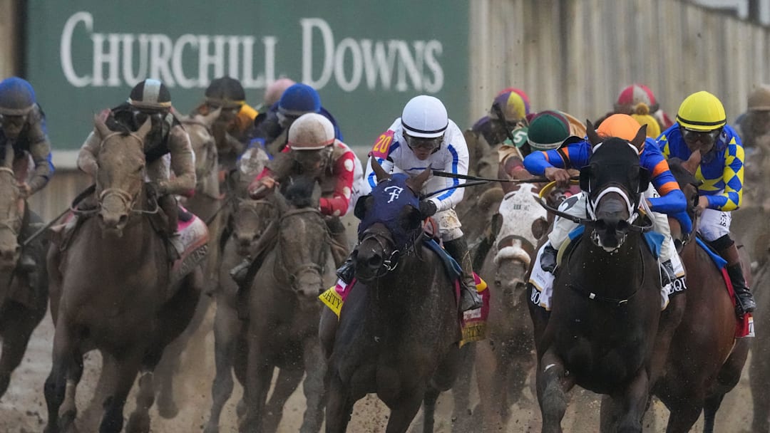 The field of horses make their way into the front stretch Saturday, May 3, 2025, during of the 151st running of the Kentucky Derby at Churchill Downs in Louisville.