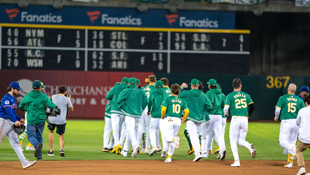 Sep 24, 2024; Oakland, California, USA; Oakland Athletics shortstop Jacob Wilson (5) and designated hitter Brent Rooker (25) and left fielder Seth Brown (15) and teammates charge the field to celebrate after the win against the Texas Rangers at Oakland-Alameda County Coliseum. Mandatory Credit: Neville E. Guard-Imagn Images