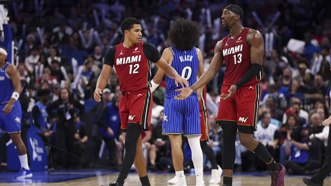 Dec 5, 2025; Orlando, Florida, USA; Miami Heat guard Dru Smith (12) reacts to center Bam Adebayo (13) after a basket against the Orlando Magic in the third quarter at Kia Center. Mandatory Credit: Nathan Ray Seebeck-Imagn Images