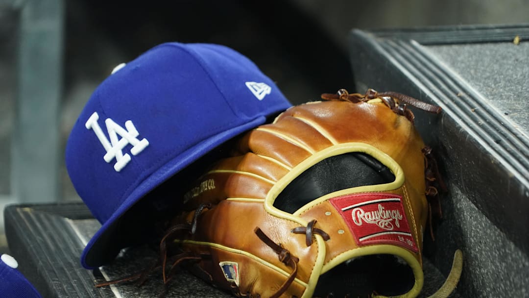 Apr 28, 2024; Toronto, Ontario, CAN; A hat and glove of an Los Angeles Dodgers player durng a game against the Toronto Blue Jays at Rogers Centre. Mandatory Credit: John E. Sokolowski-Imagn Images