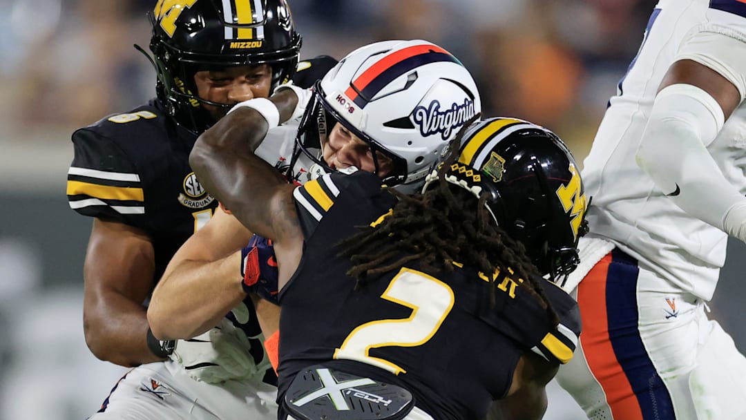 Virginia Cavaliers wide receiver Eli Wood (82) is tackled by Missouri Tigers cornerback Toriano Pride Jr. (2) as safety Jalen Catalon (6) helsp during the first quarter of the TaxSlayer Gator Bowl at EverBank Stadium, Saturday, Dec. 27, 2025, in Jacksonville. Fla. [Corey Perrine/Florida Times-Union]