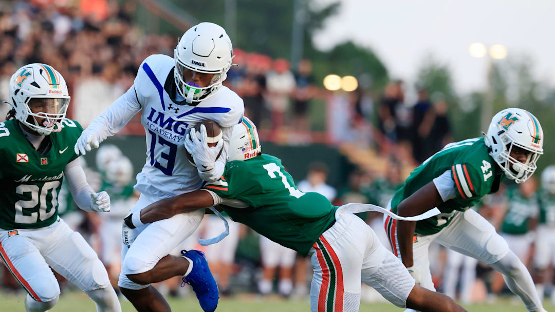 IMG Academy's Osani Gayles (13) rushes for yards against Mandarin's Tamajh Mitchell (7) during the first quarter of a high school football matchup at Mandarin High School, Friday, Sept. 19, 2025, in Jacksonville, Fla. The IMG Academy Ascenders defeated the Mandarin Mustangs 57-7.