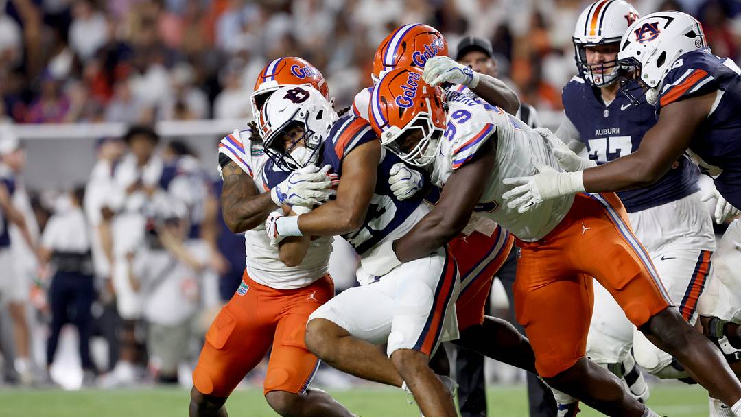 Sep 19, 2026; Auburn, Alabama, USA;  Florida Gators defensive end Emmanuel Oyebadejo (99) and other Gator defenders tackle Auburn Tigers running back Jeremiah Cobb (23) during the third quarter at Jordan-Hare Stadium.  Mandatory Credit: John Reed-Imagn Images