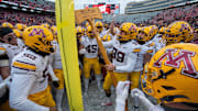 Minnesota players pretend to cutdown the goal post with the Paul Bunyan Football Trophy after their game at Camp Randall Stadium Friday, November 29, 2024 in Madison, Wisconsin. Minnesota beat Wisconsin 24-7.