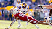 Arkansas Razorbacks quarterback Taylen Green (10) is tackled by LSU Tigers defensive end Jack Pyburn (44) during the first half at Tiger Stadium. 